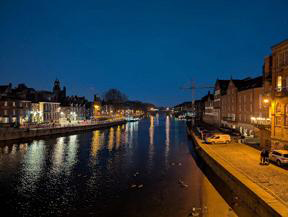 York at night, the lights reflecting in the river. 